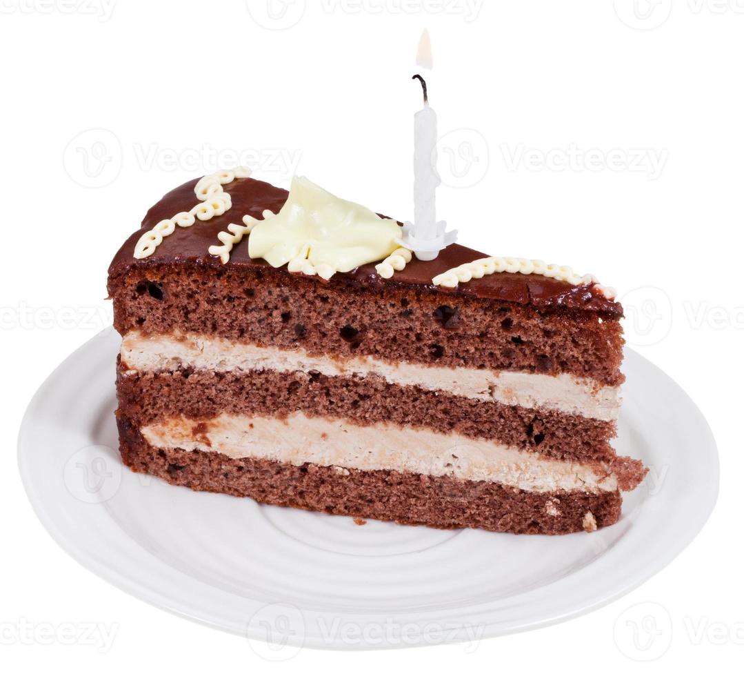 piece of chocolate cake with burning candle photo