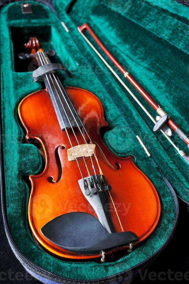 violín con arco en caja de terciopelo verde foto