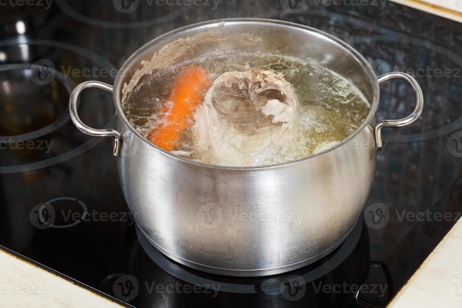 simmering chicken soup with seasoning vegetables photo