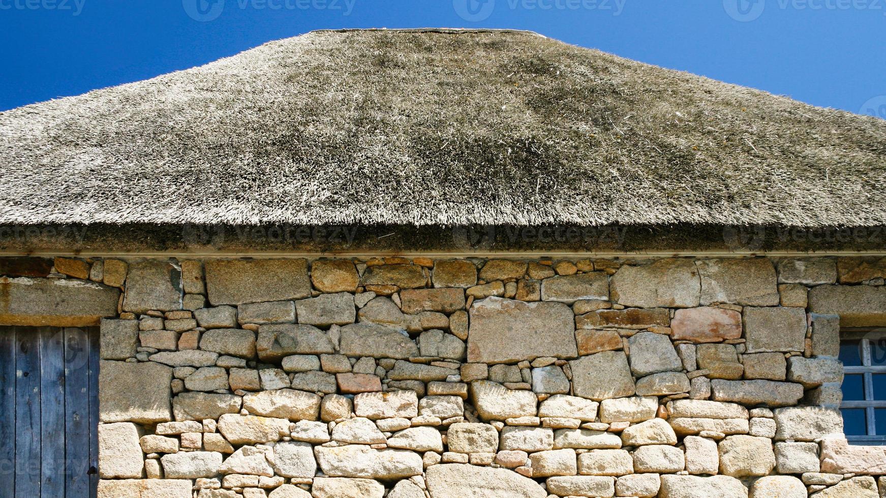 wall and thatched roof of old country house photo