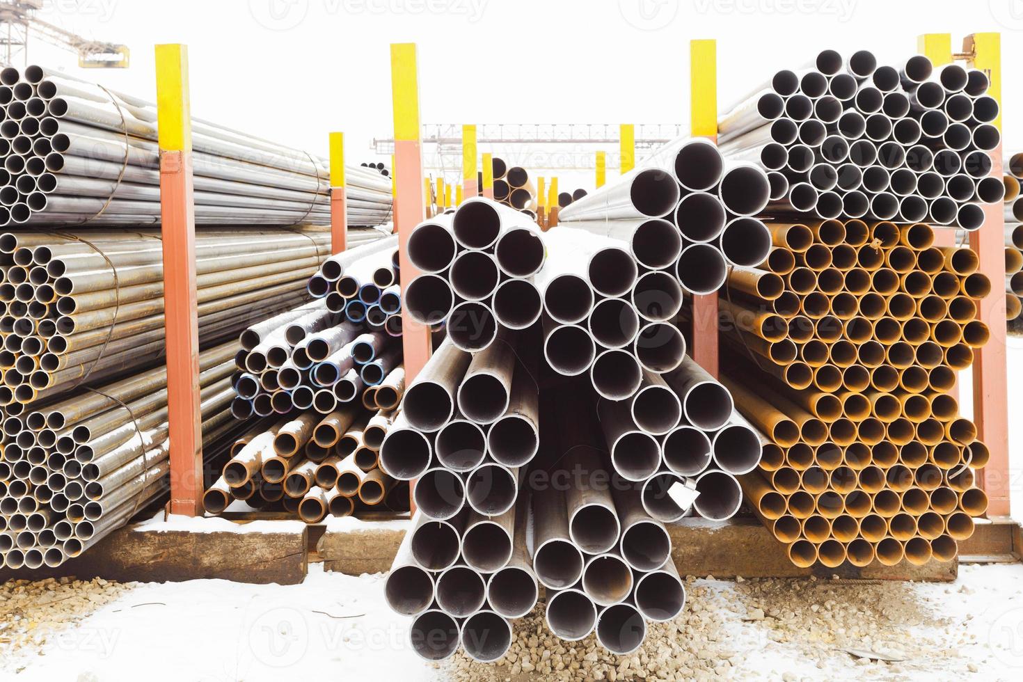 piles of different pipes in outdoor warehouse photo