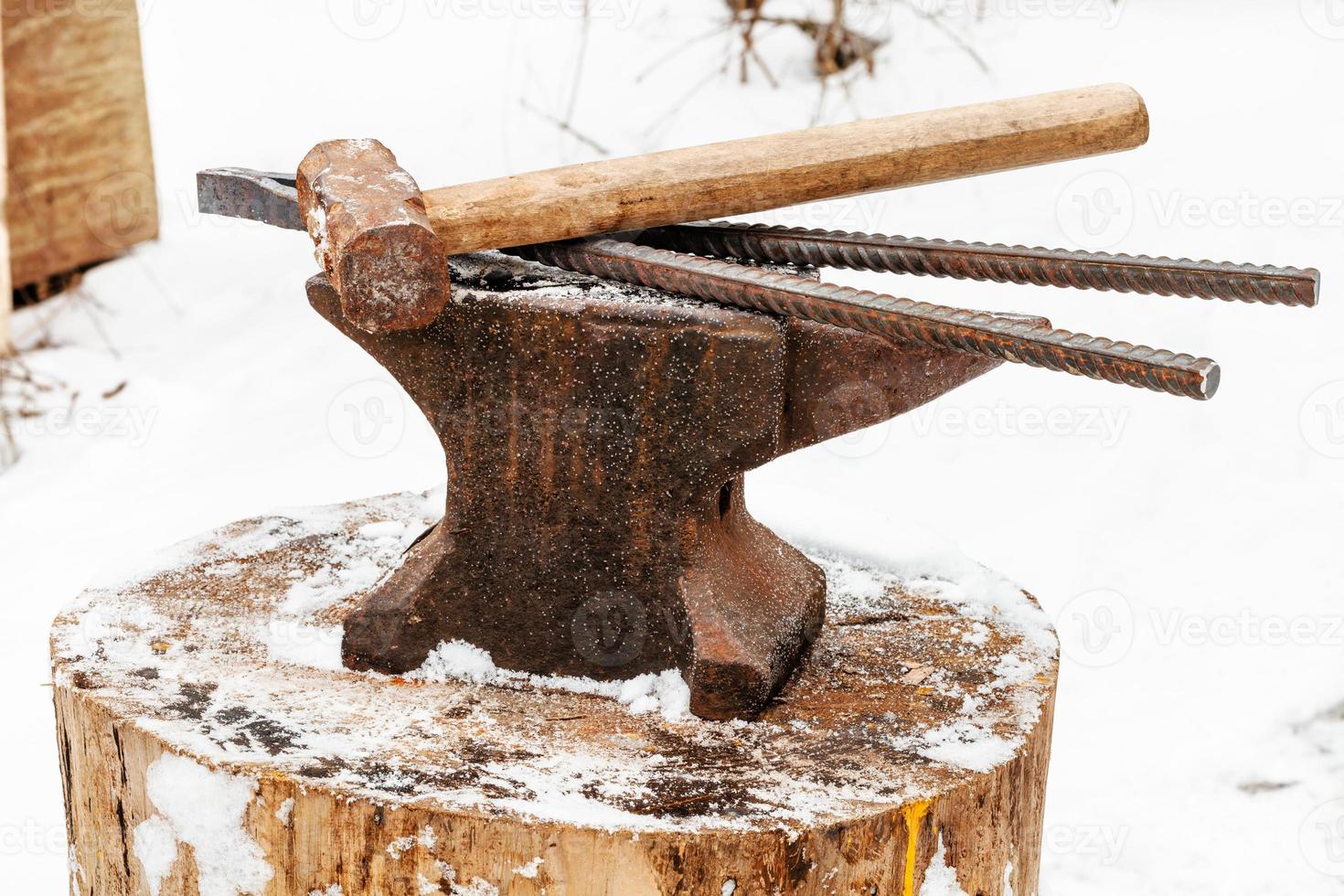 anvil with blacksmith tongs hammer in smithy photo