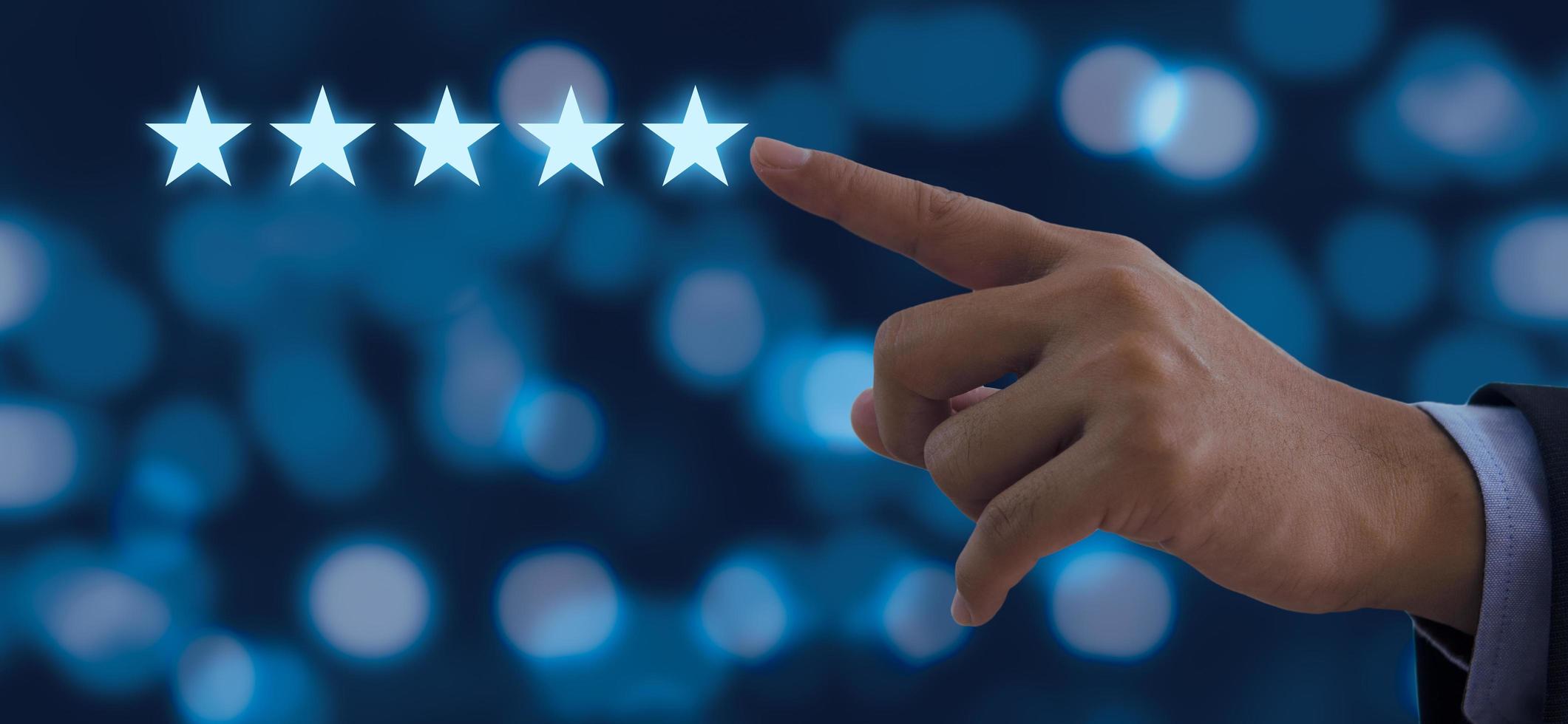 Hand of businessman touching five stars symbol to increase rating on background photo