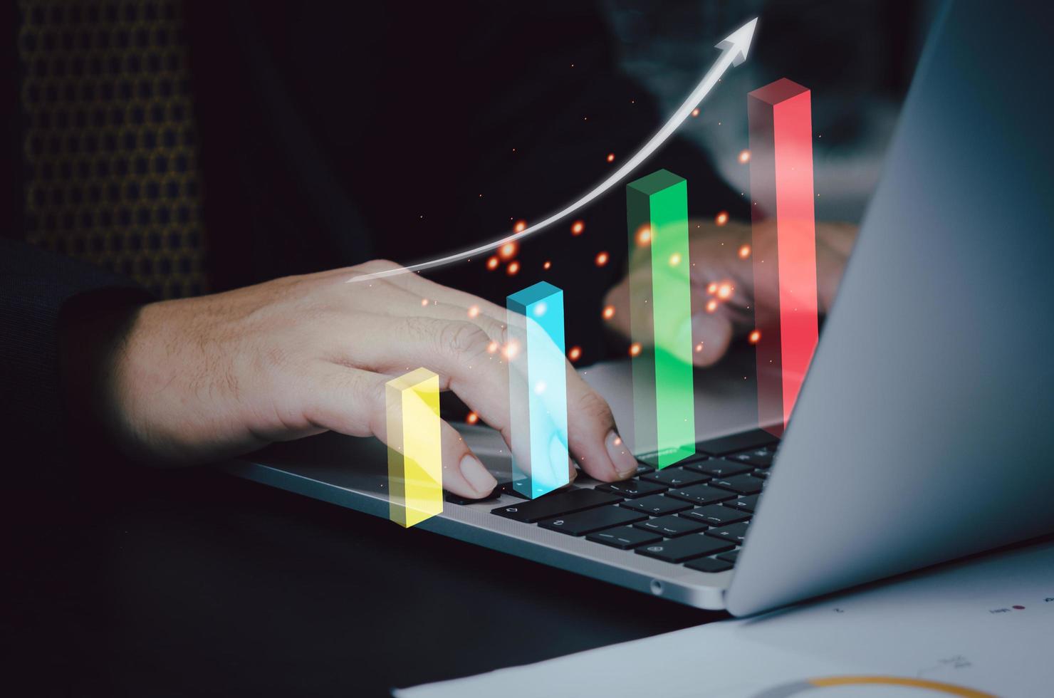 gráfico y pantalla virtual de flecha con computadora portátil en el escritorio. el gráfico de análisis de crecimiento de la inversión empresarial aumenta el concepto de ingresos. foto