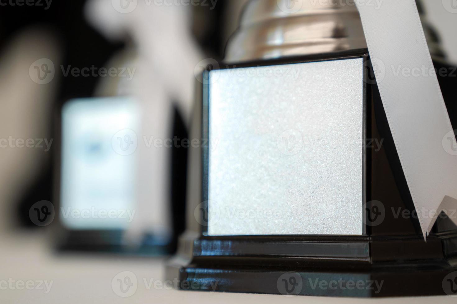 Three Trophies on circle white table with tree leaf background in Seminar hall. photo