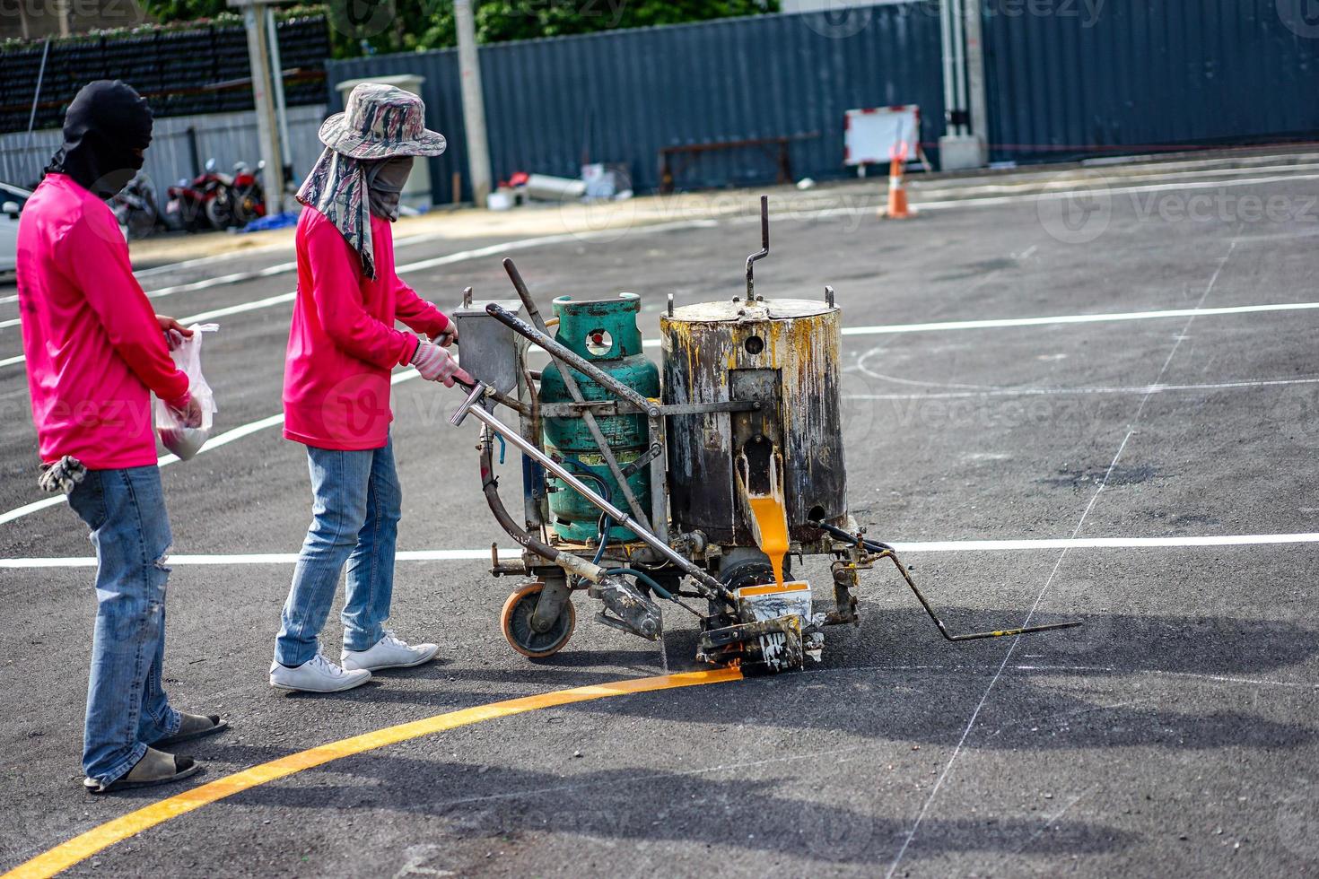 Workers are lining on the asphalt roat with paint the thermoplastic by machine photo