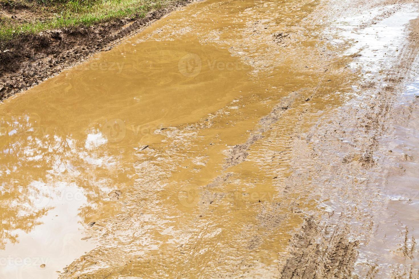 mud and puddle in rut of dirt ground road photo