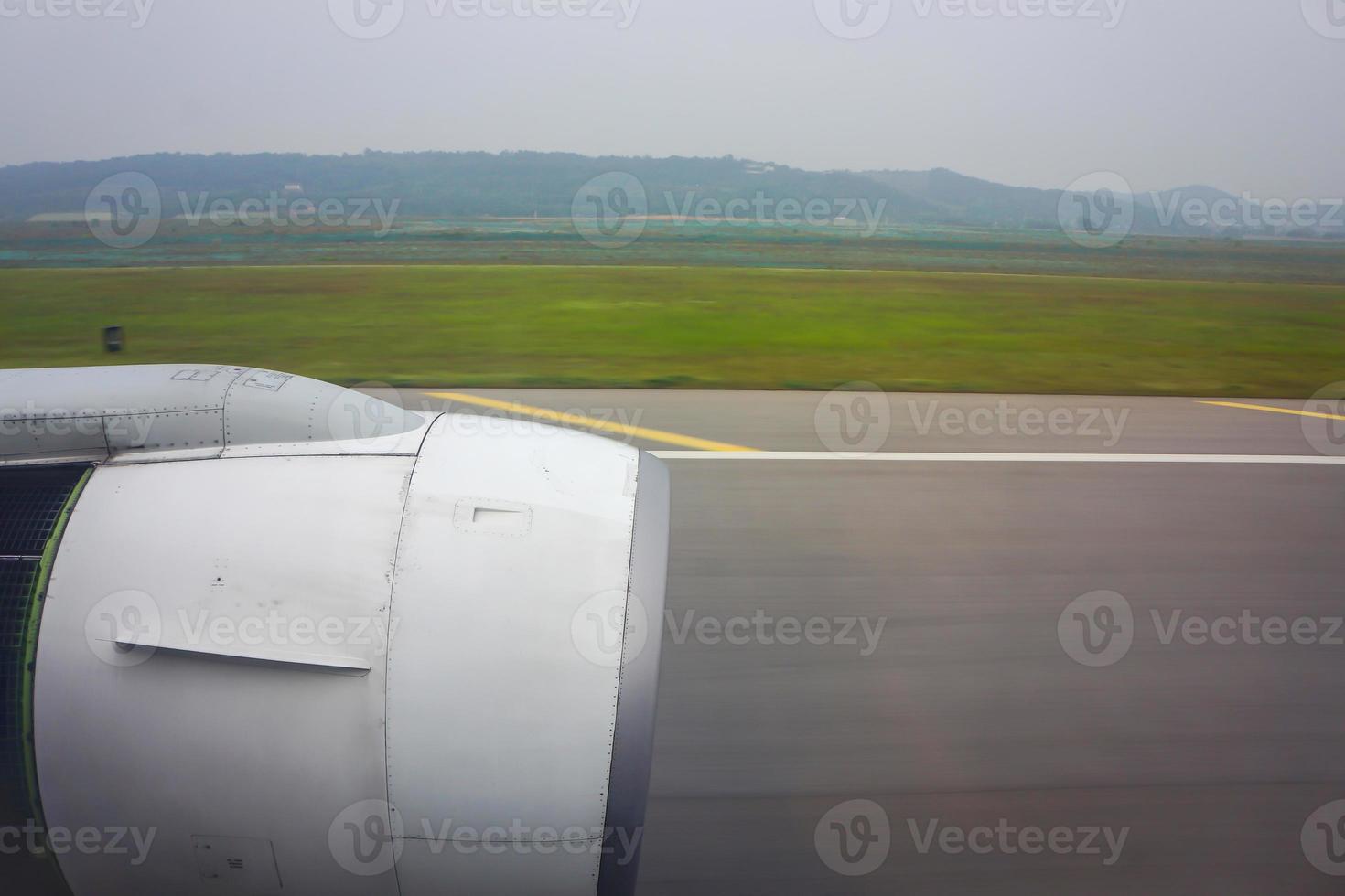 jet plane window sky view with machine wing between landing in airport. photo