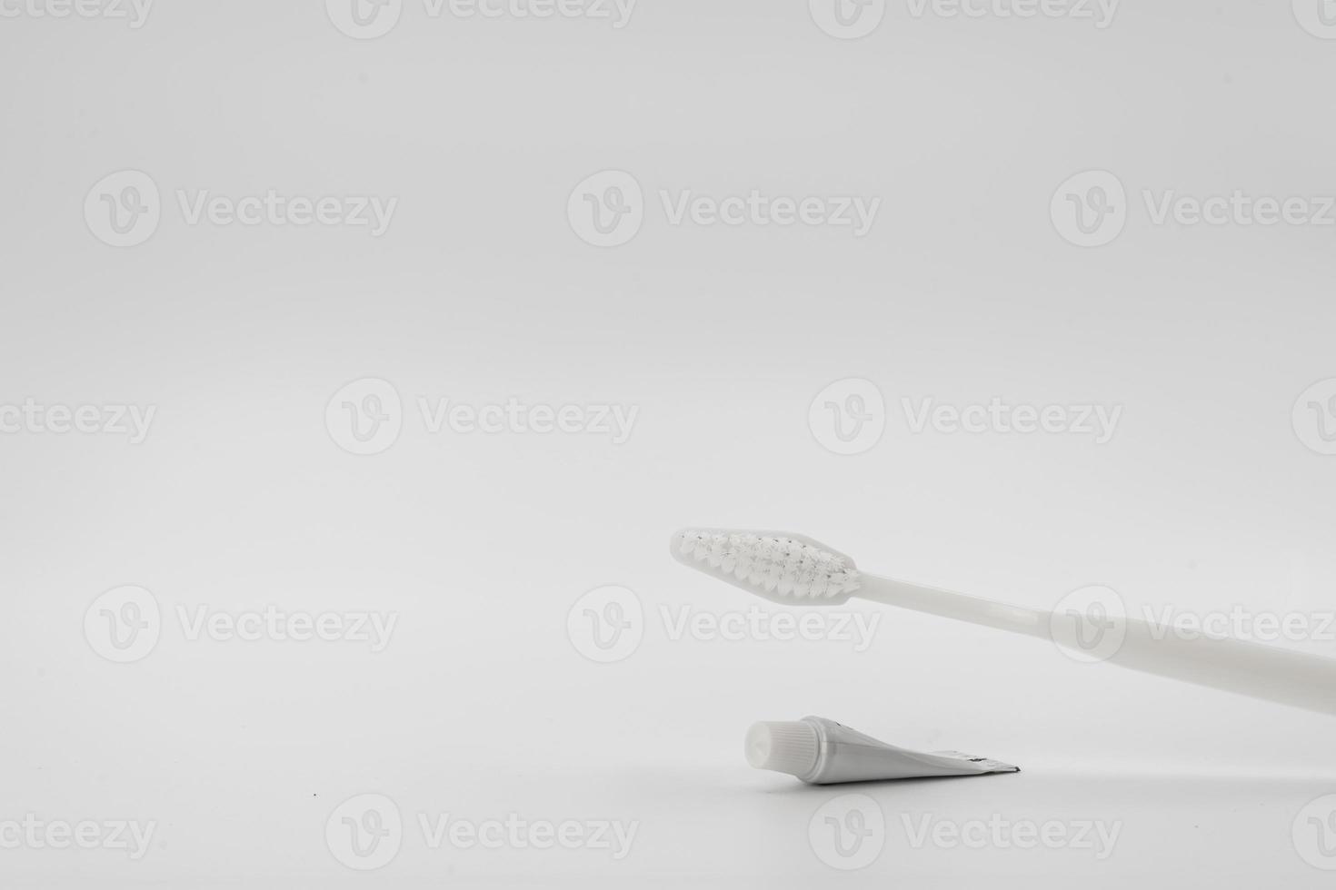 Isolated simple and normal white toothbrush with small toothpaste on the white background in studio light. photo