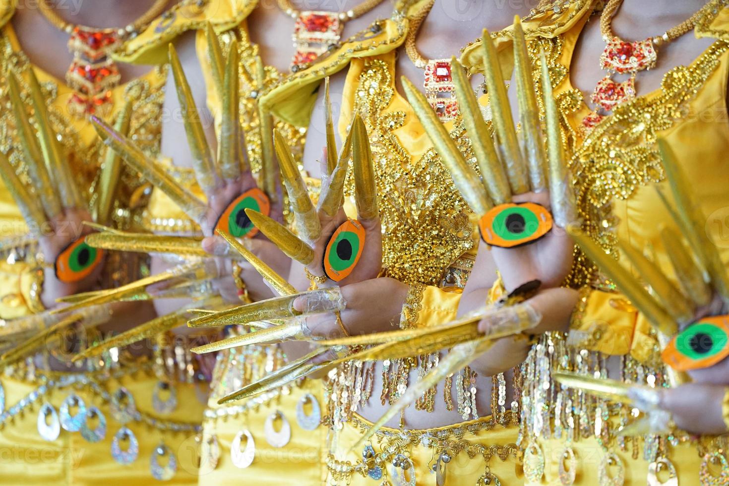 Performance traditional show, with the amazing luxury yellow Indian dress style., They are posting and standing in a row of photo shooting section.