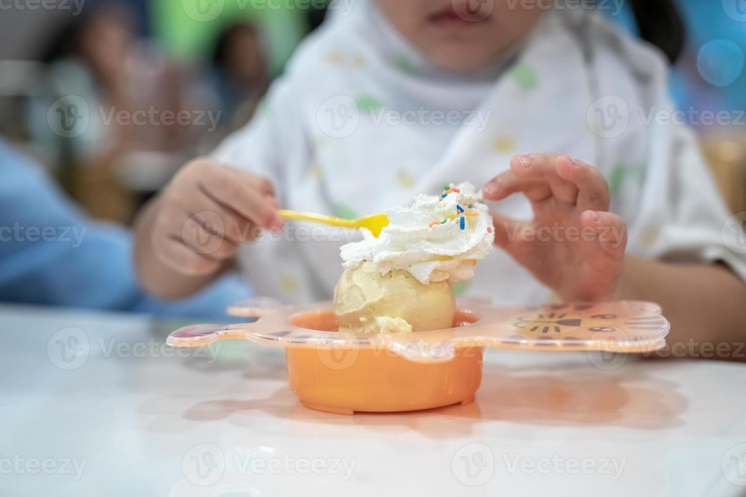 kid is eating icecream and whip cream in the icecream restaurant
