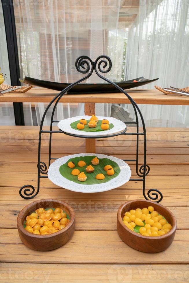 Traditional Luxury Gold colour Thai Dessert in good luck meaning set  JaMongKut, SaNayChan, ThongAek, MedKaNoon are set in the tower set in the garden outdoor feel. photo