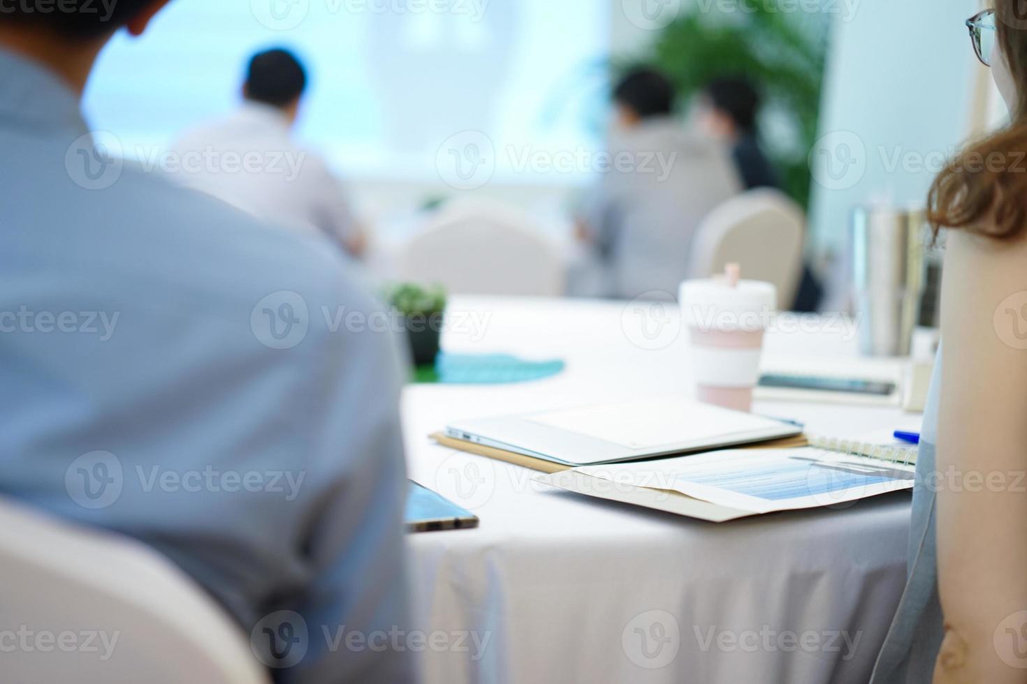 Man and Woman listen to speaker in front of hall in business seminar course. photo