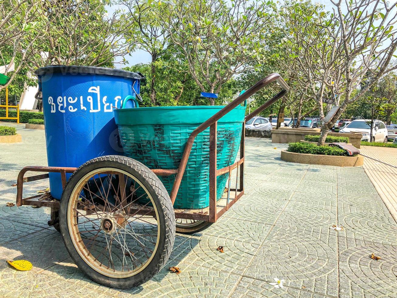 Wet Waste garbage plastic can on the three wheel Thailand local trolley parks in the park. Thai letter language text in picture means Wet Waste photo