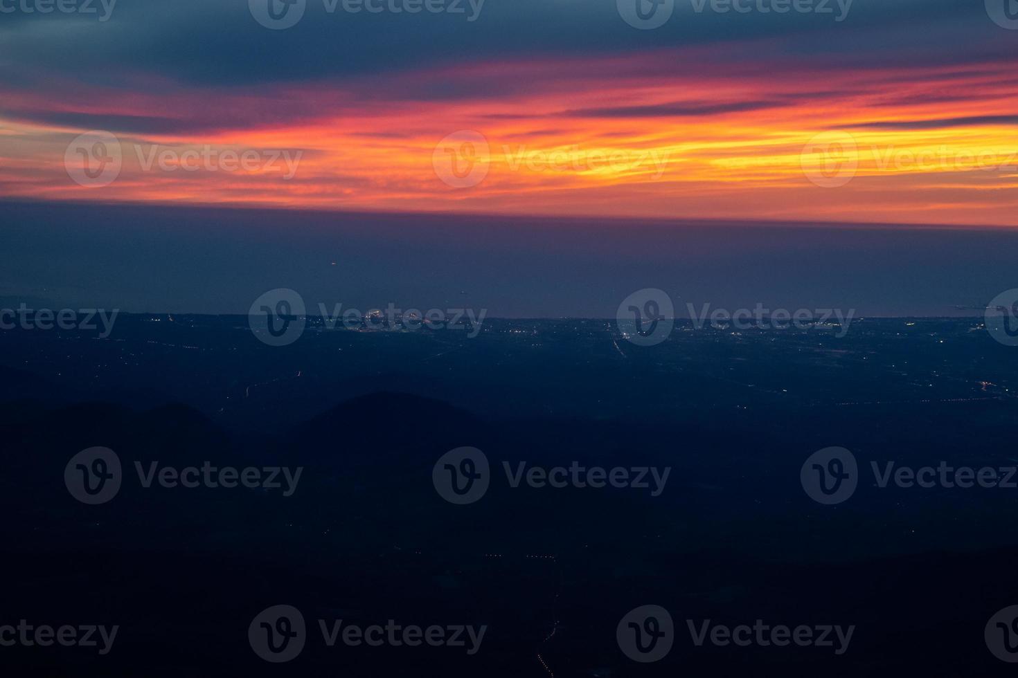 Twilight to Night from the jet plane view red orange blue sky with the light of Thailand city below photo