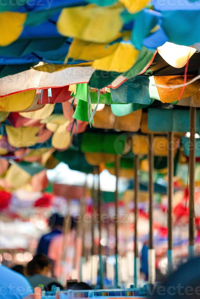 Old and tear Umbrella open to protect the sunshine for Tourists at the Bangsaen Beach Chonburi Thailand. photo