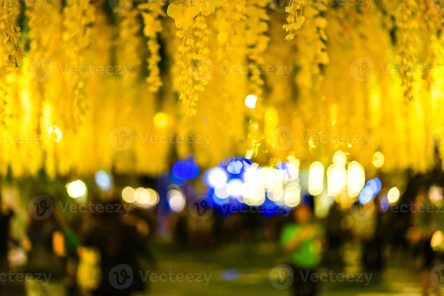 muchas flores amarillas en el techo por la noche con bokeh detrás. foto