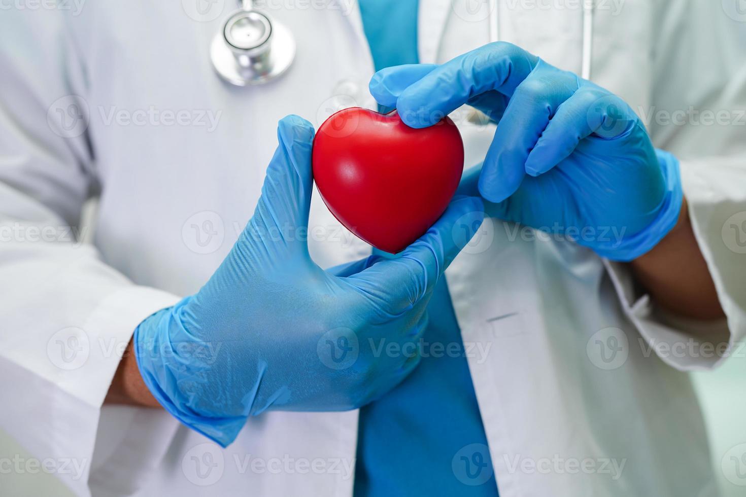 Asian woman doctor holding red heart for health in hospital. photo