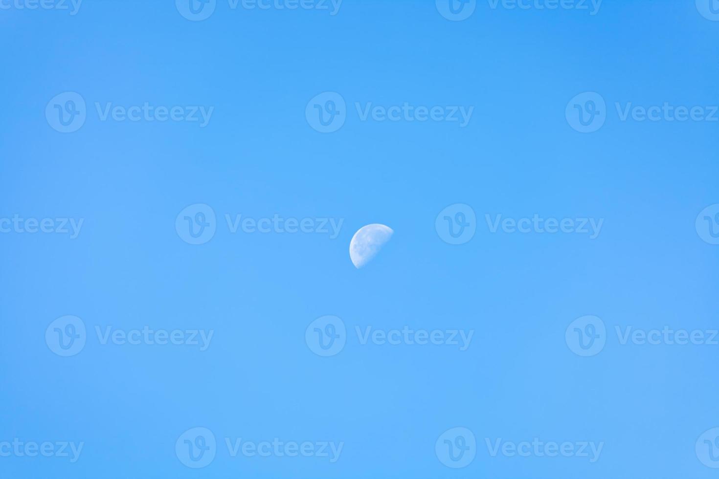 half of moon in clear blue morning sky photo