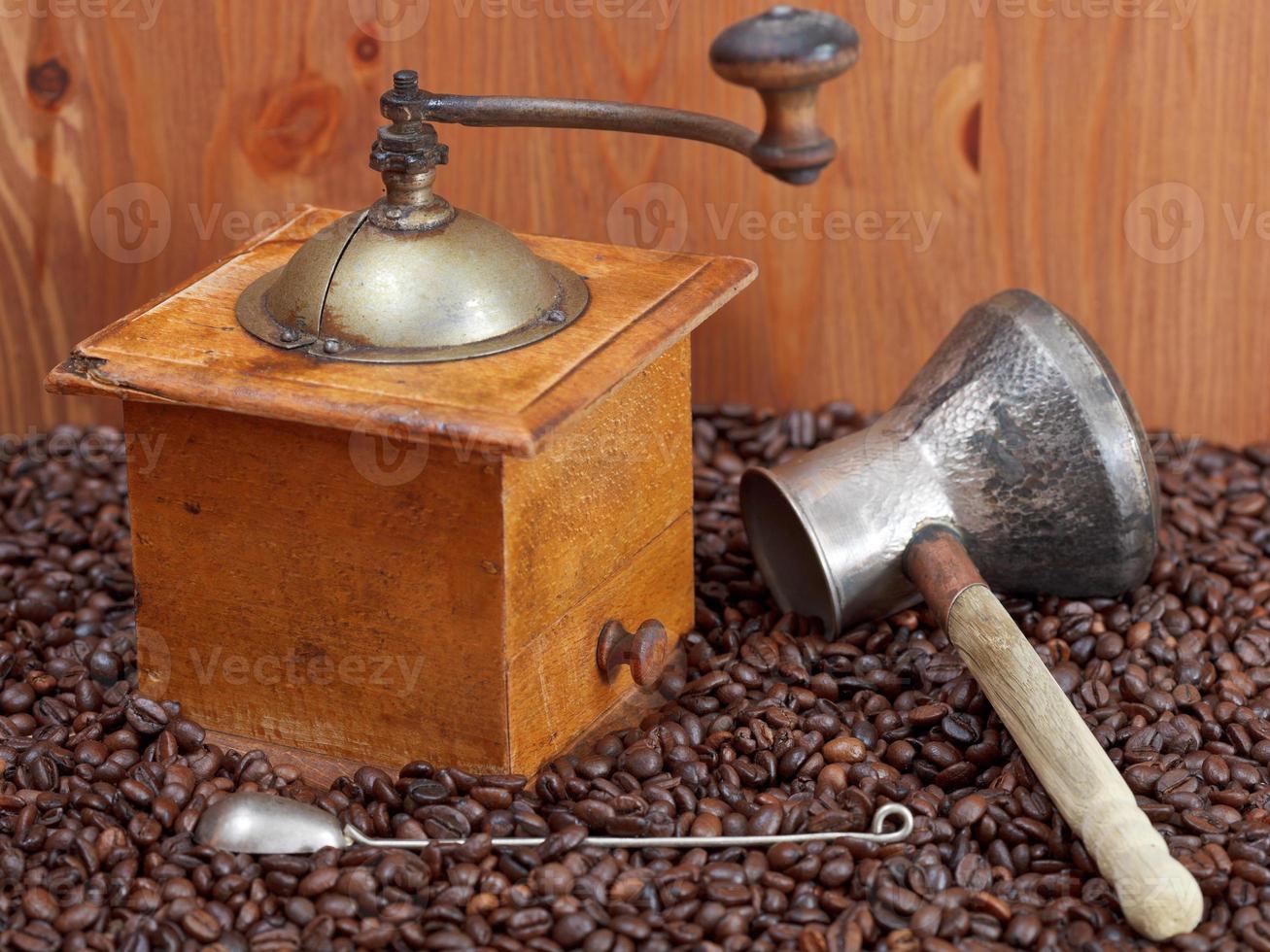 coffee grinder and copper pot on roasted beans photo