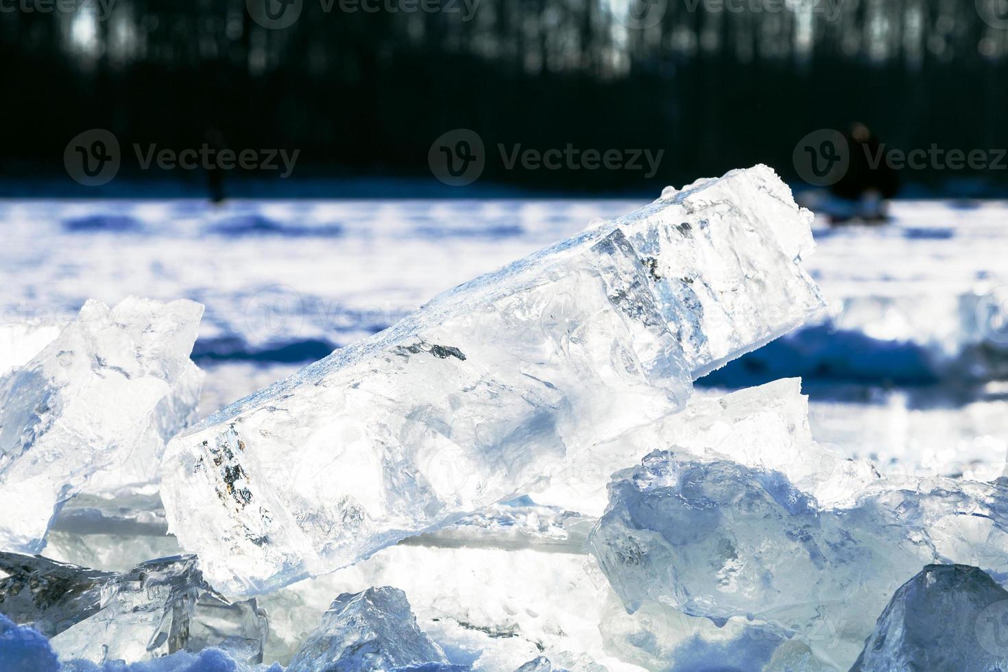 ice blocks illuminated by sun on frozen lake photo