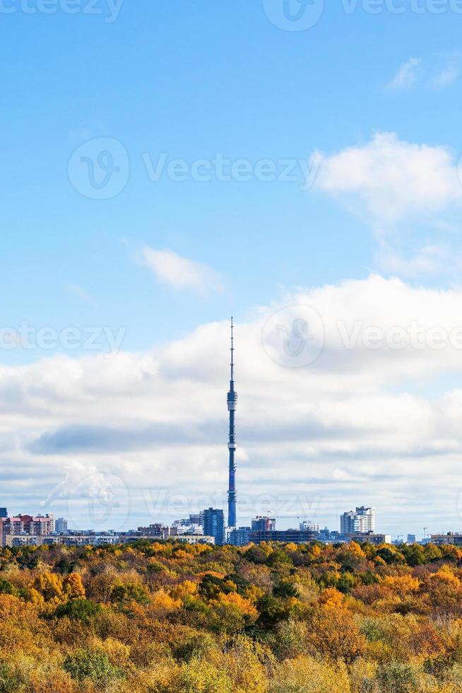 cielo azul sobre el bosque otoñal y la ciudad con torre de televisión foto