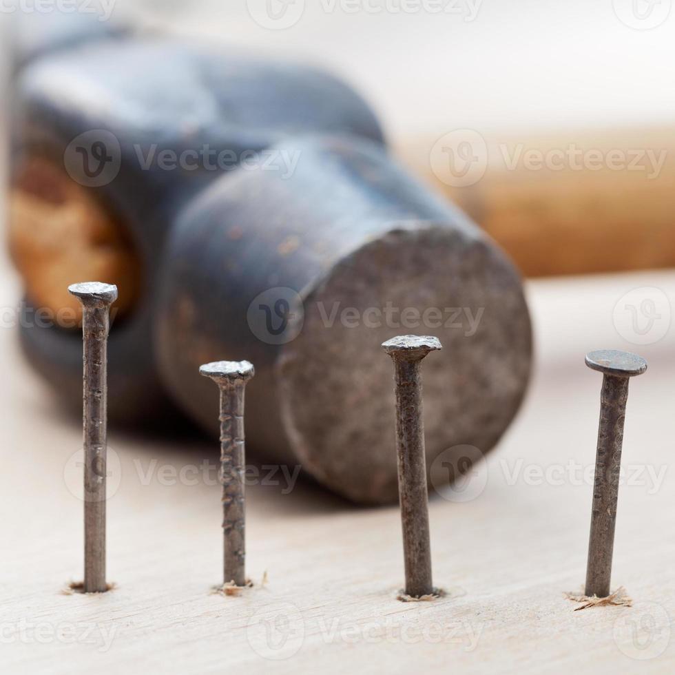 martillo y clavos en tablones de madera foto