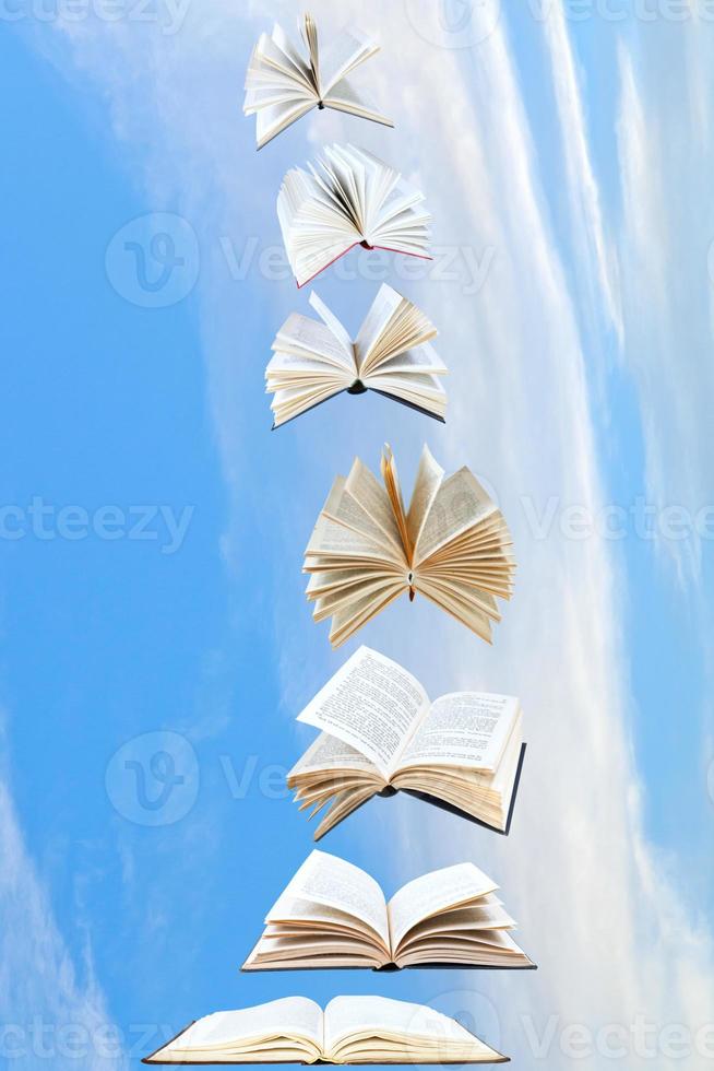 stack of books fly in blue sky photo