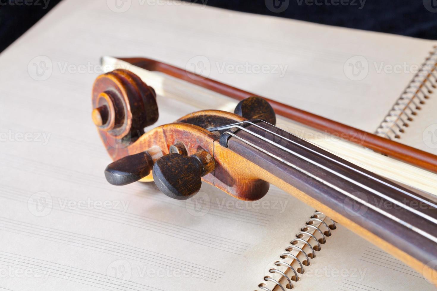 violin bow and scroll on music book photo
