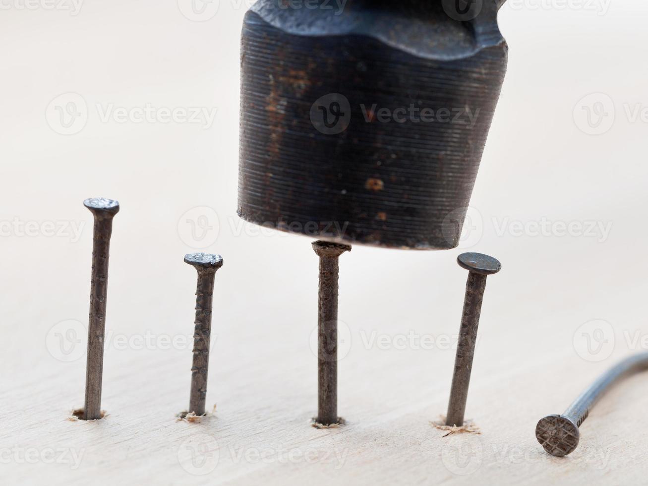 hammer nails into wooden board photo