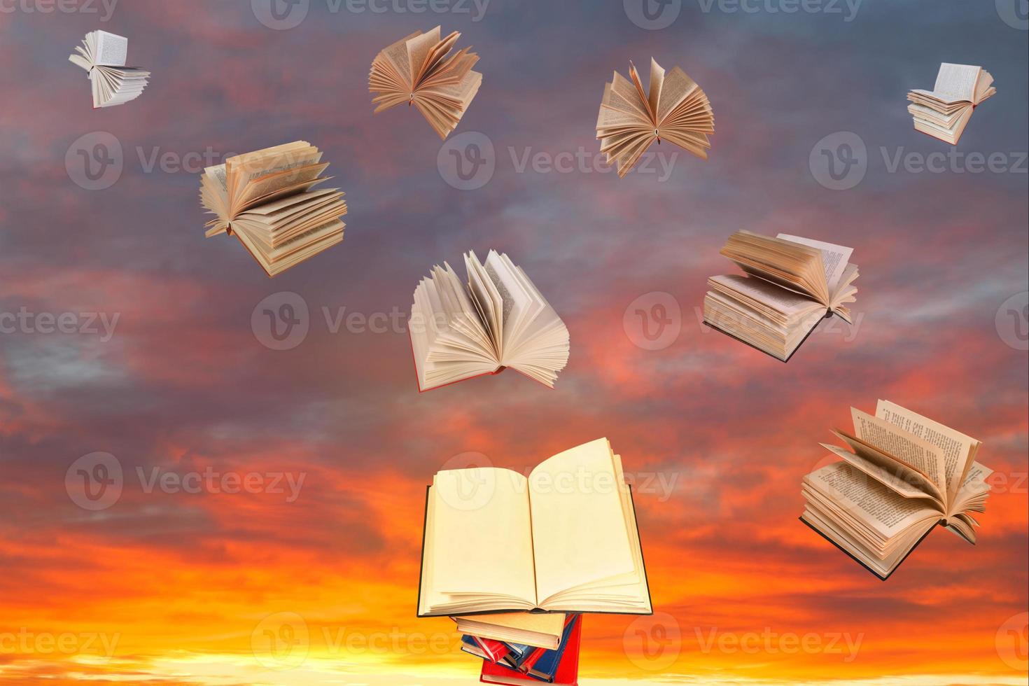 book above of stack of books and sunset sky photo