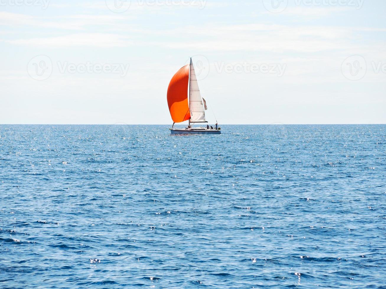 yacht with red sail in blue Adriatic sea photo