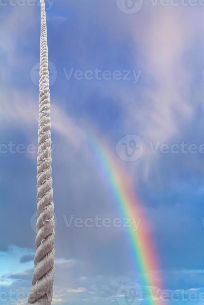 rope rises in blue sky with rainbow photo
