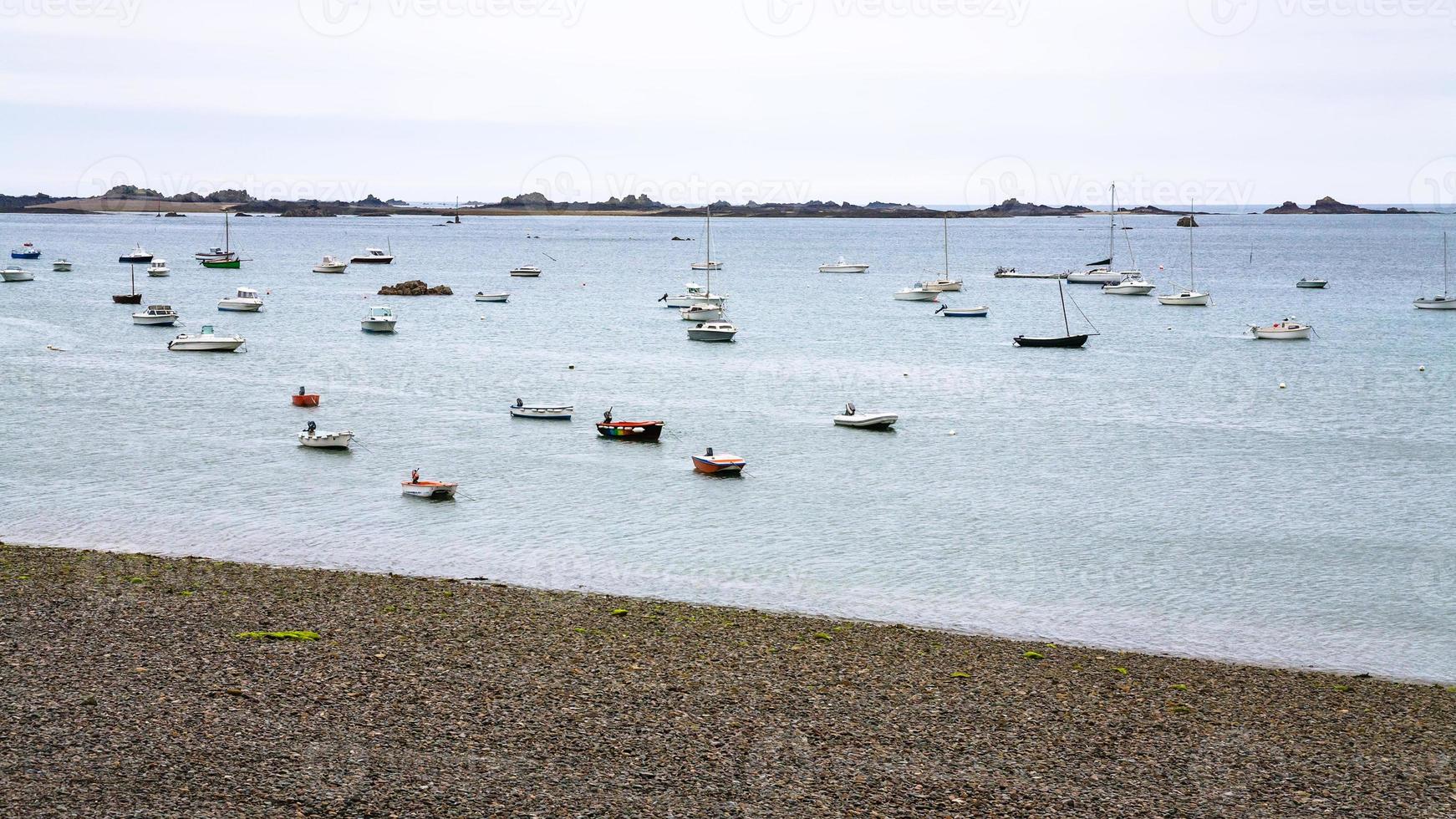 boats moored near pebble beach in Ploubazlanec photo