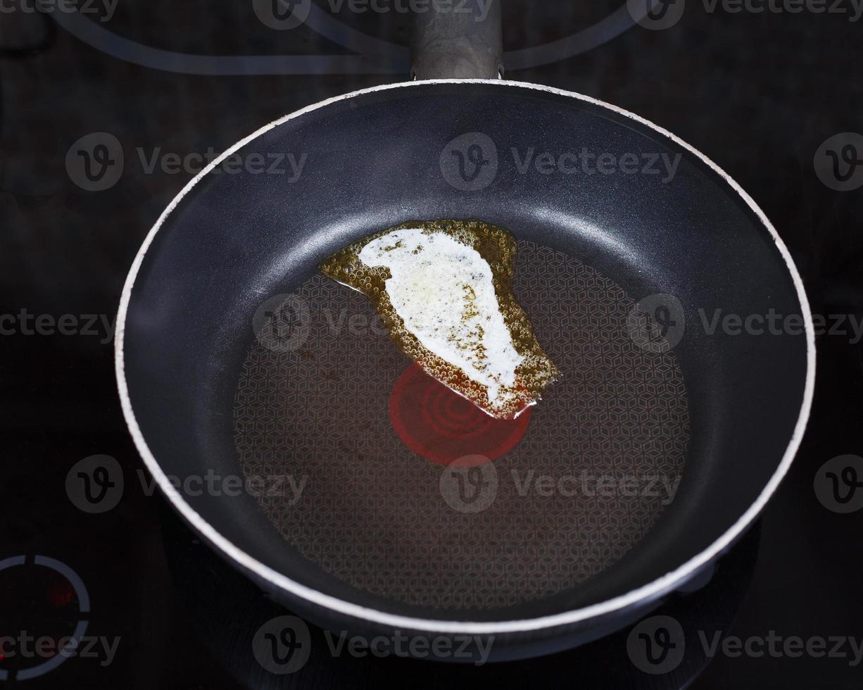 small piece dairy butter melting on pan photo