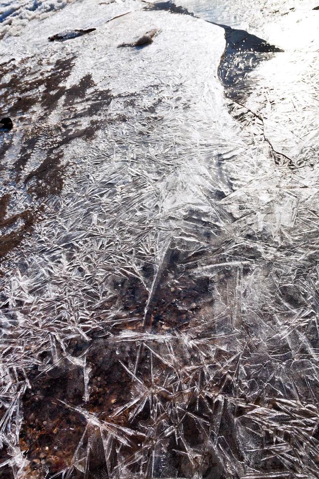 crust of ice on frozen stream photo