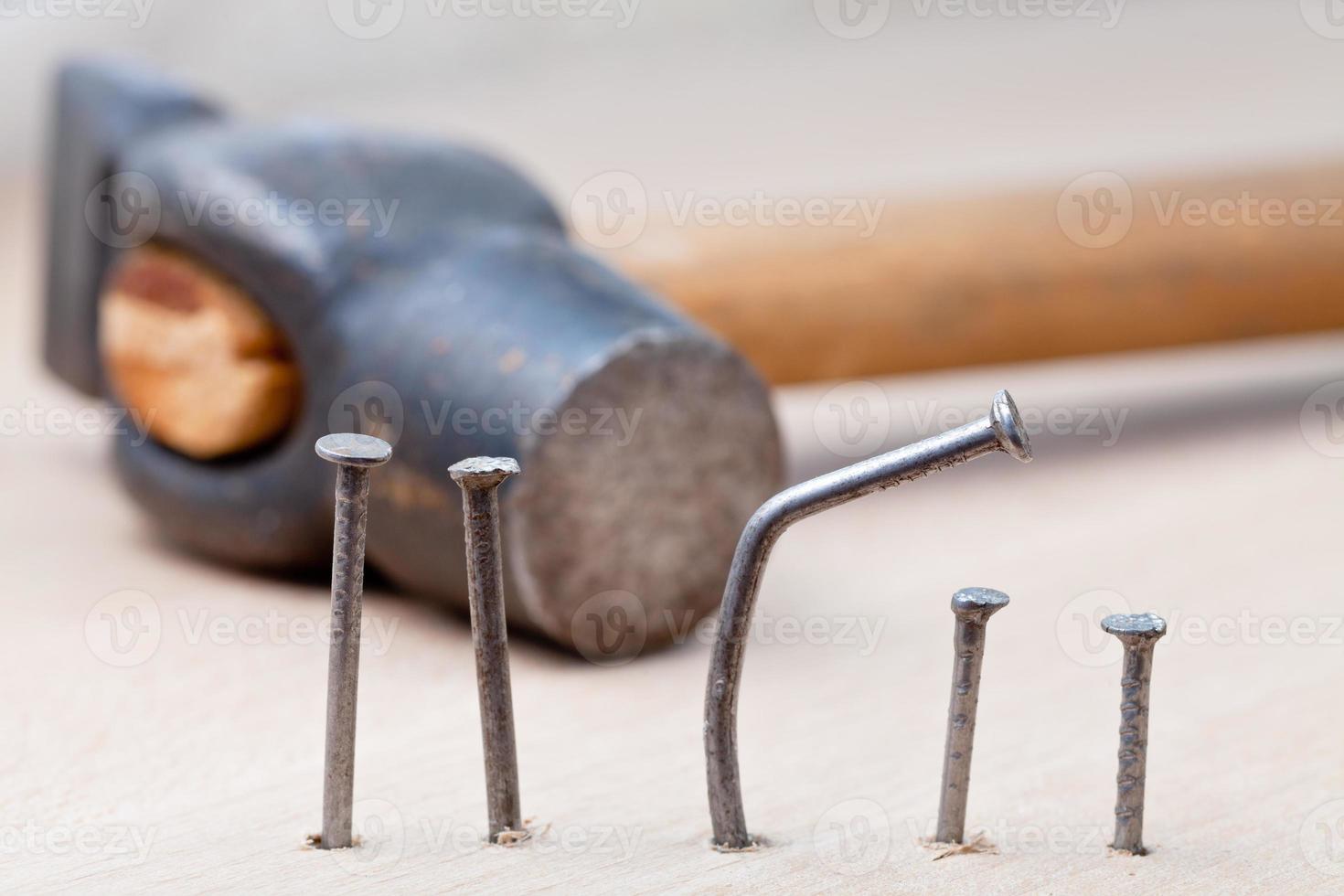hammer nails into wooden board photo