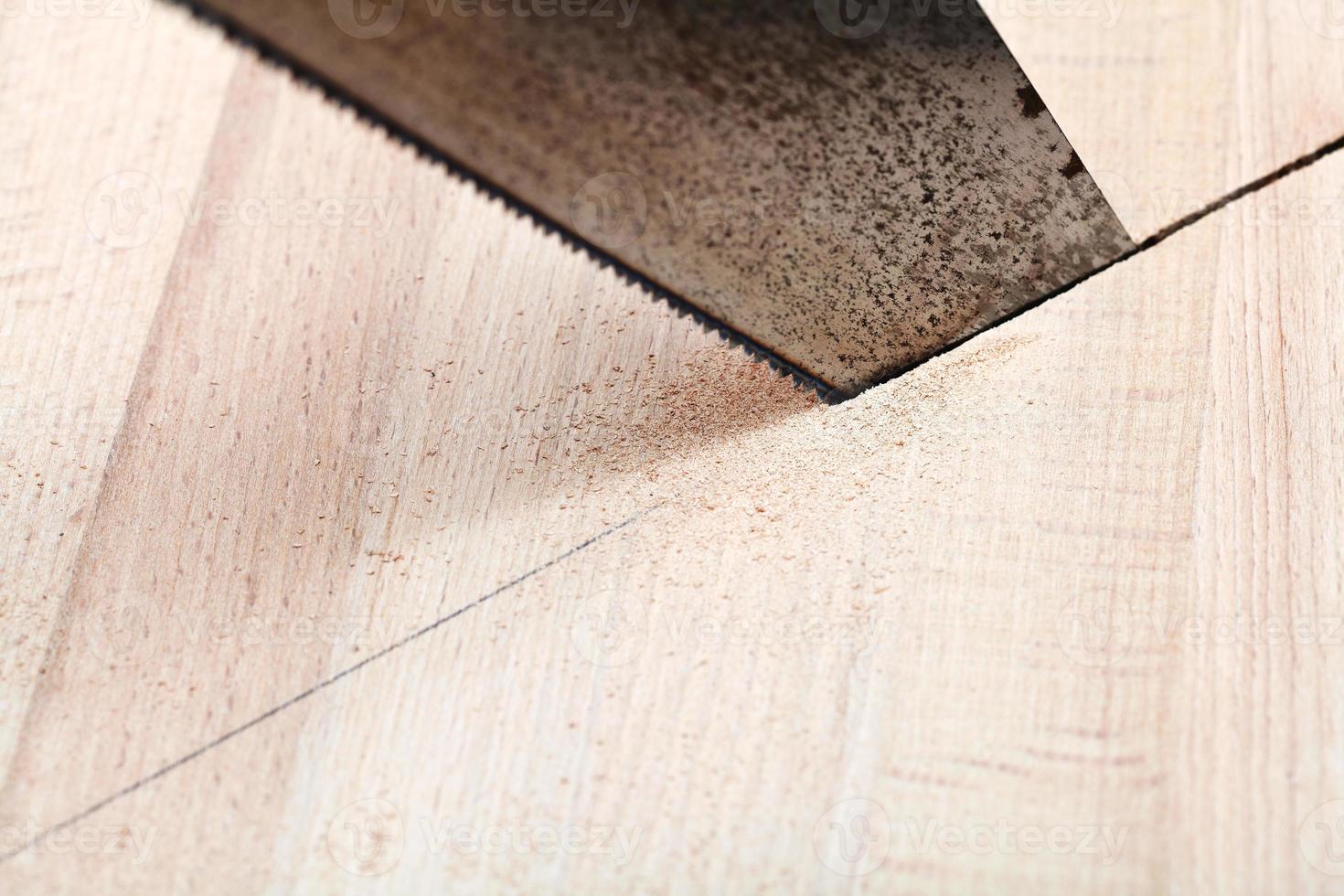 wooden plank is cut with hacksaw photo