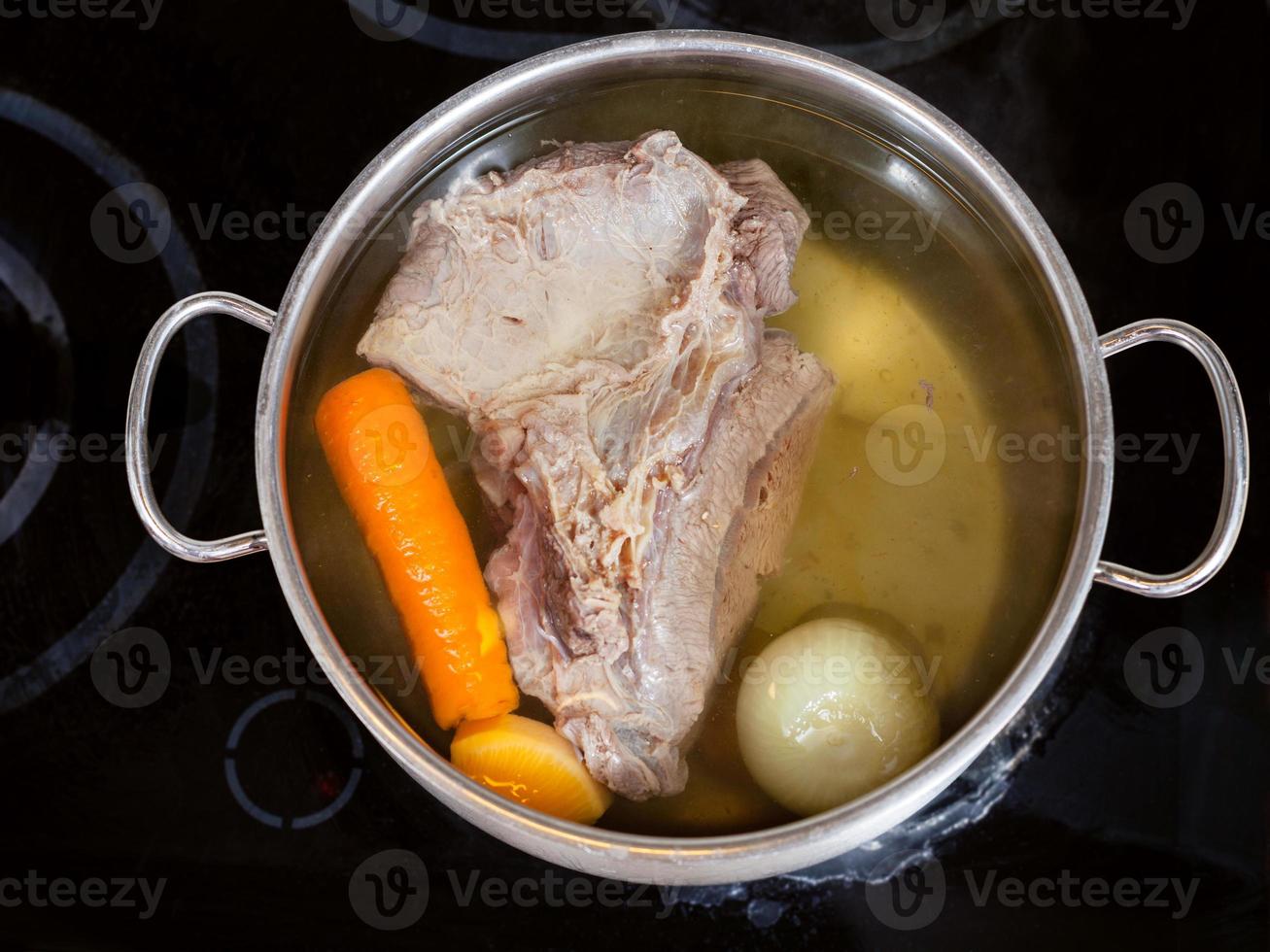 open pan with boiling beef broth photo