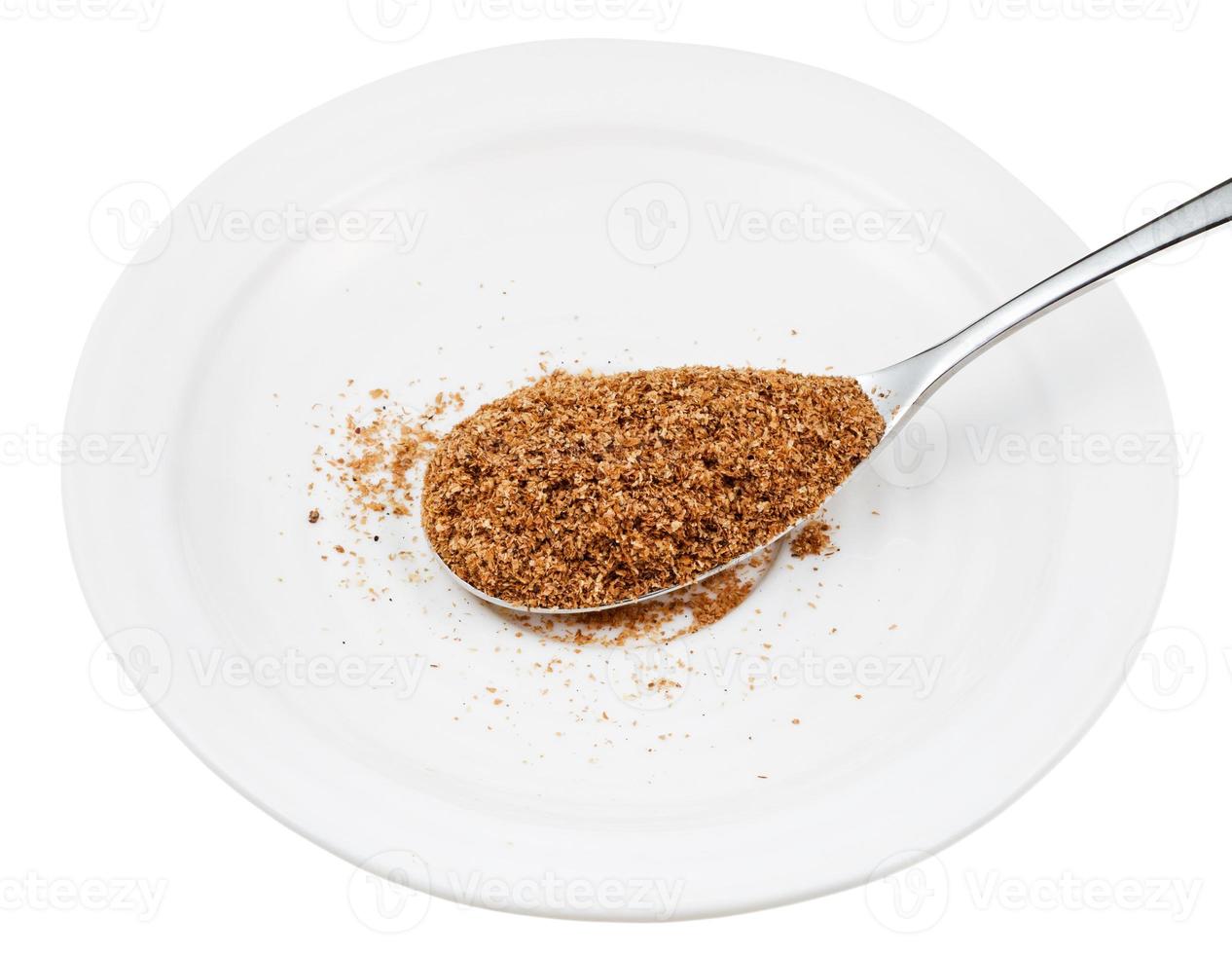 spoon of wheat bran on white plate photo