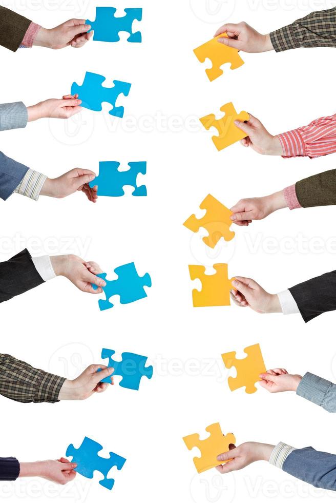 yellow and blue puzzle pieces in people hands photo