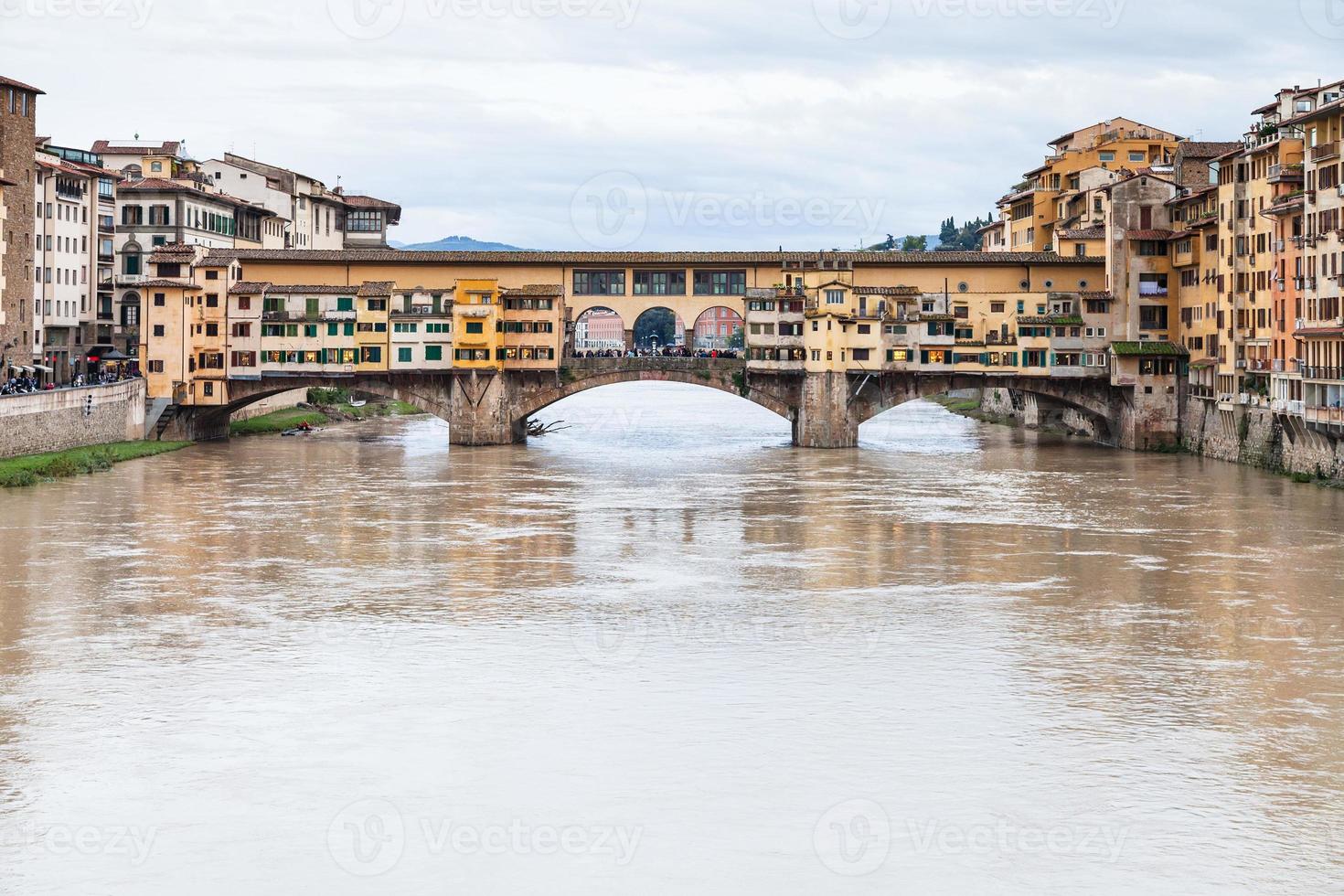 agua turbia de arno y ponte vecchio en otoño foto