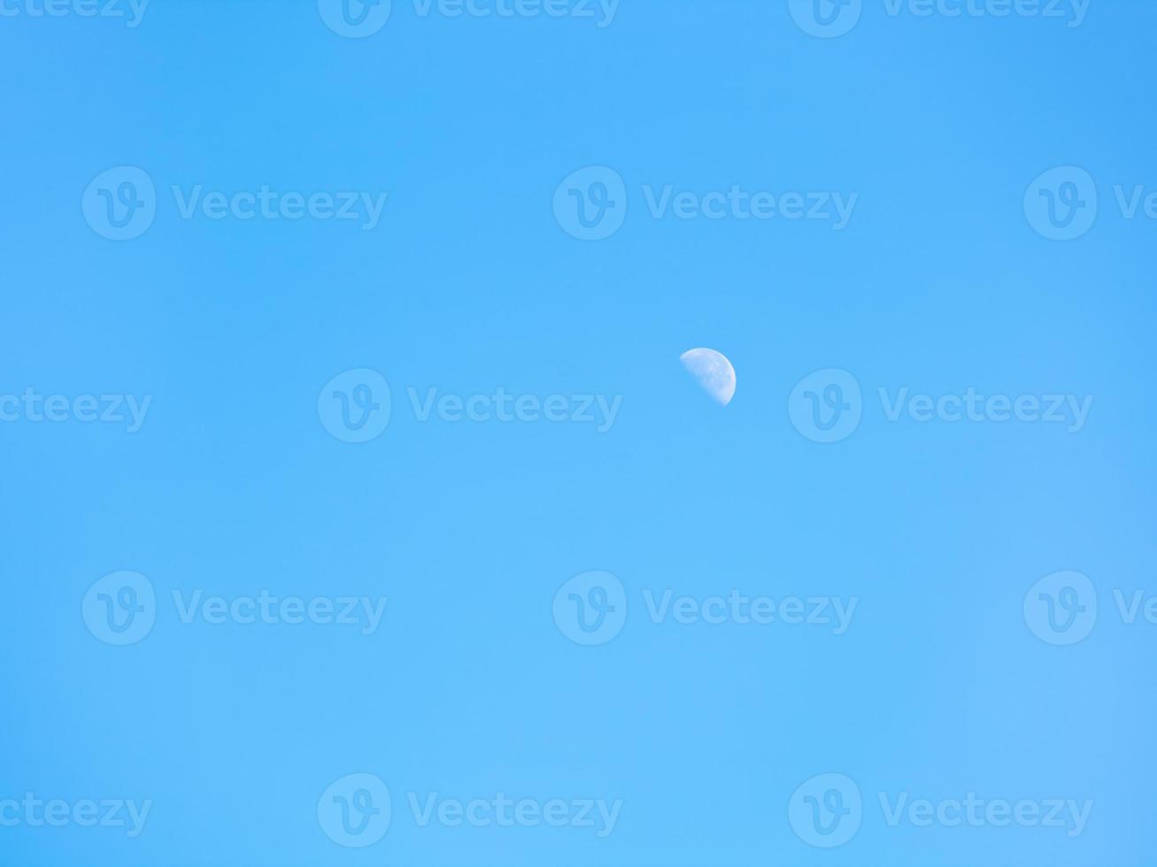 half of moon in clear blue autumn sky photo