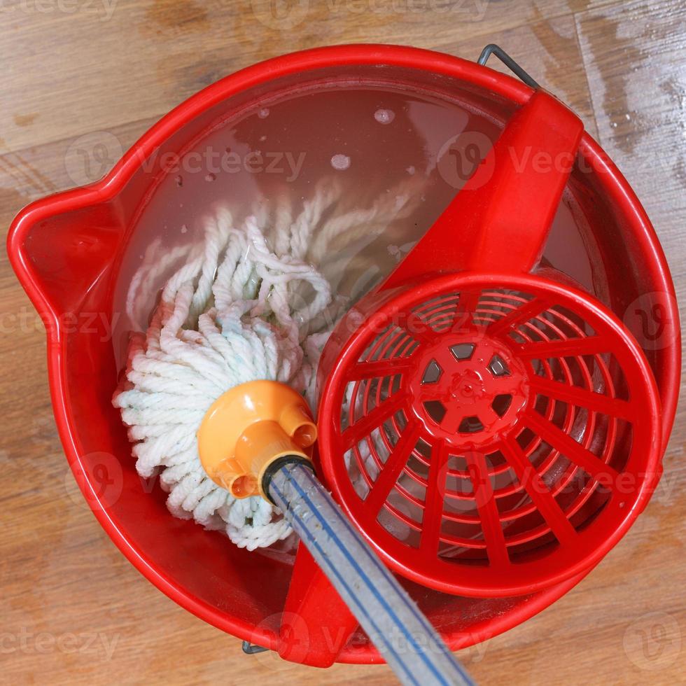 washing mop in red bucket photo