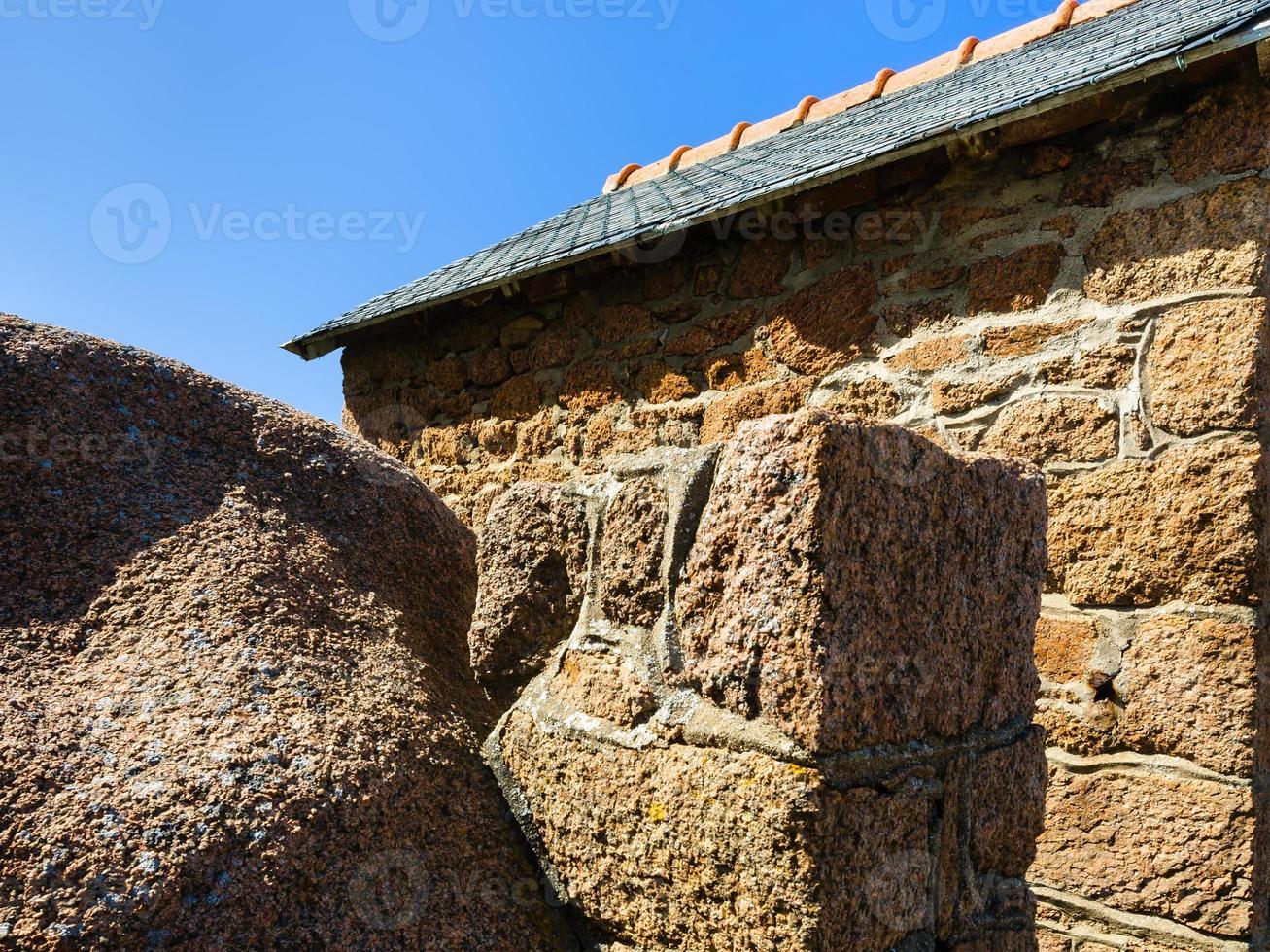 boulder and wall of breton house in Ploumanach photo