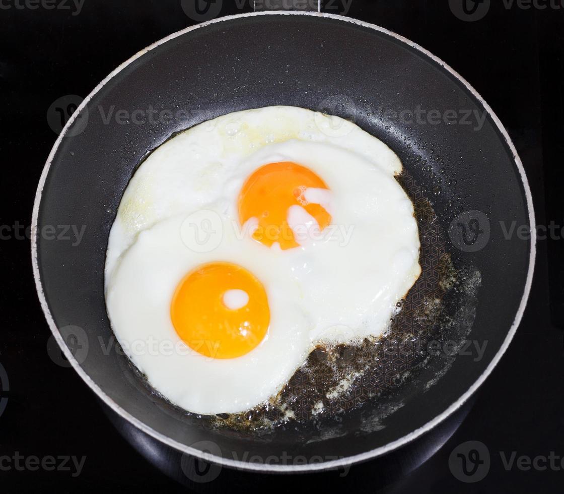 top view of two fried eggs in frying pan photo