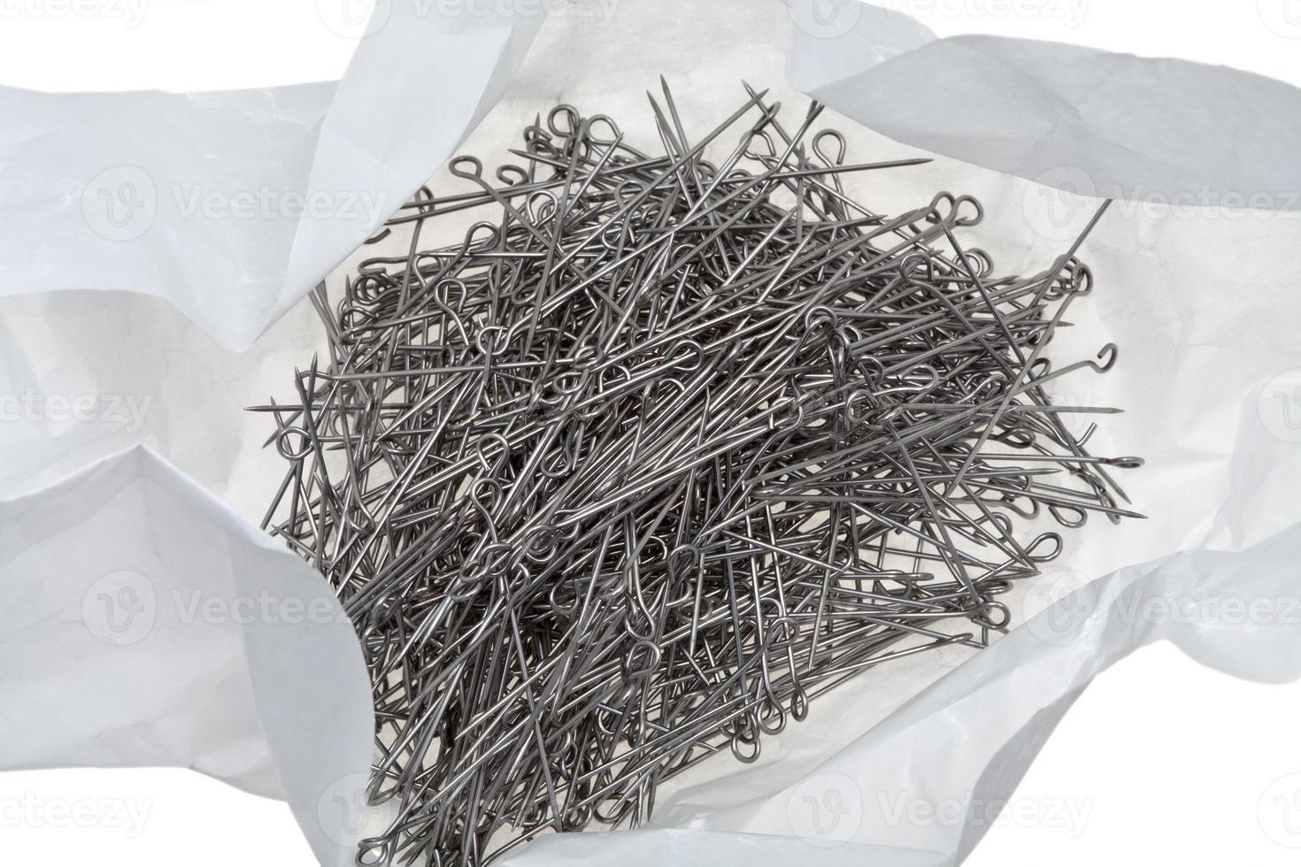 many steel tailor's pins in unwrap paper packet photo