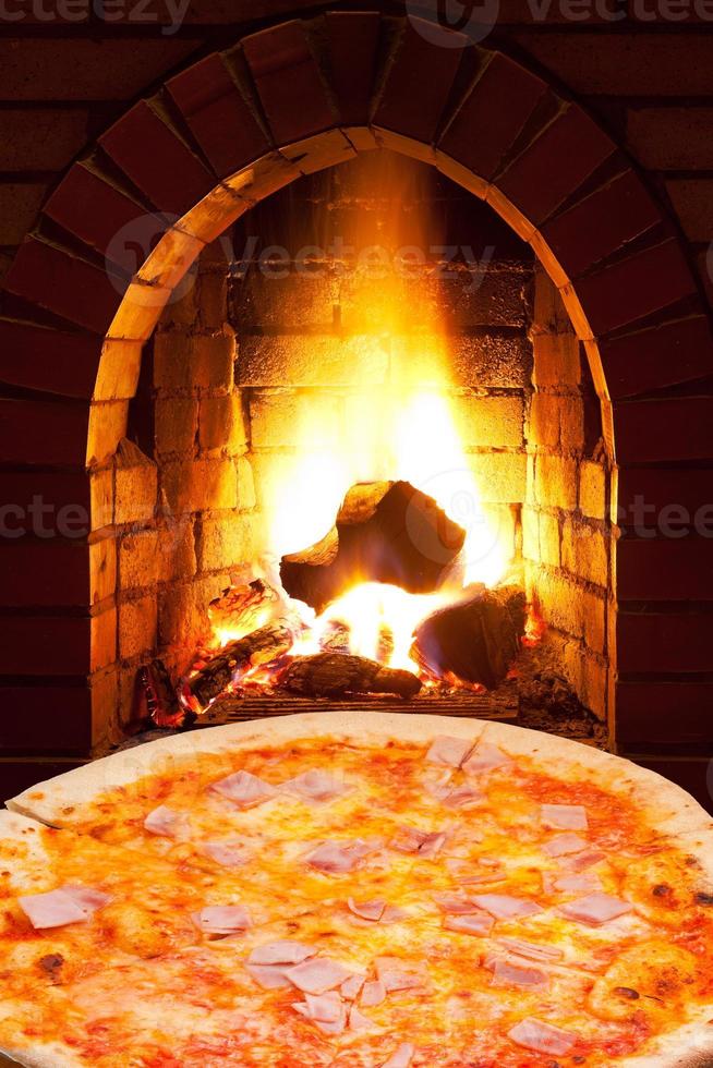 pizza with ham and open fire in oven photo