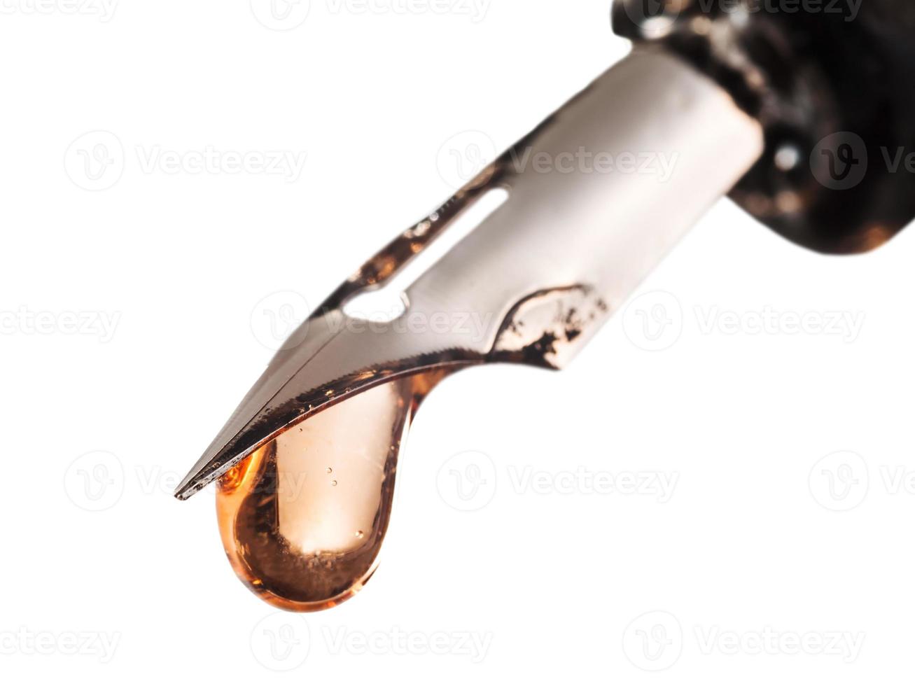 drop of transparent color water on tip of pen photo