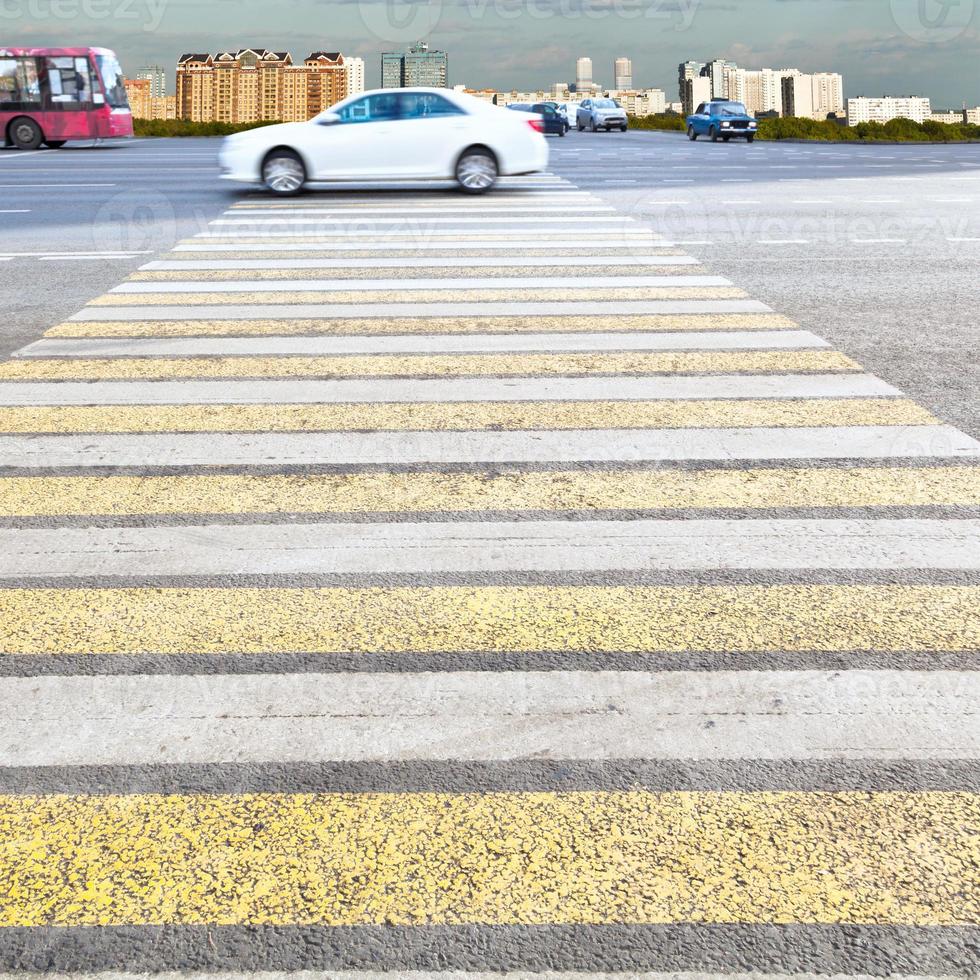 yellow and white crossing zebra on urban street photo